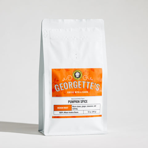 A white stand-up coffee bag with a prominent orange label reading Georgette's Coffee, Pumpkin Spice, on a light gray studio background.