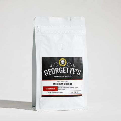 A white stand-up coffee bag with a black and white label reading Georgette's Coffee, Michigan Cherry, on a clean white background.