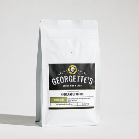 A white stand-up coffee bag with a large black front label reading Georgette's Coffee, Highlander Grogg, photographed on a clean light gray studio background.