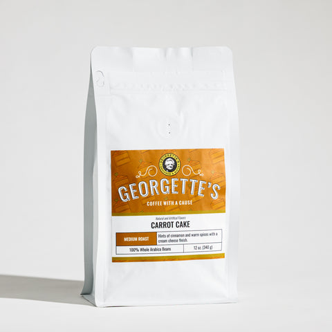 A white stand-up coffee bag with a large orange and white label reading Georgette's Coffee, Carrot Cake, photographed on a clean white background.