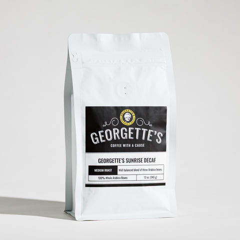 A white stand-up coffee bag labeled Georgette's Coffee, Georgette's Sunrise Decaf, photographed on a light gray studio background.